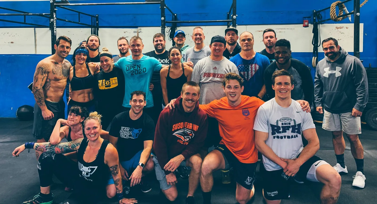 A large group of PowerPack Fitness members posing together in the gym